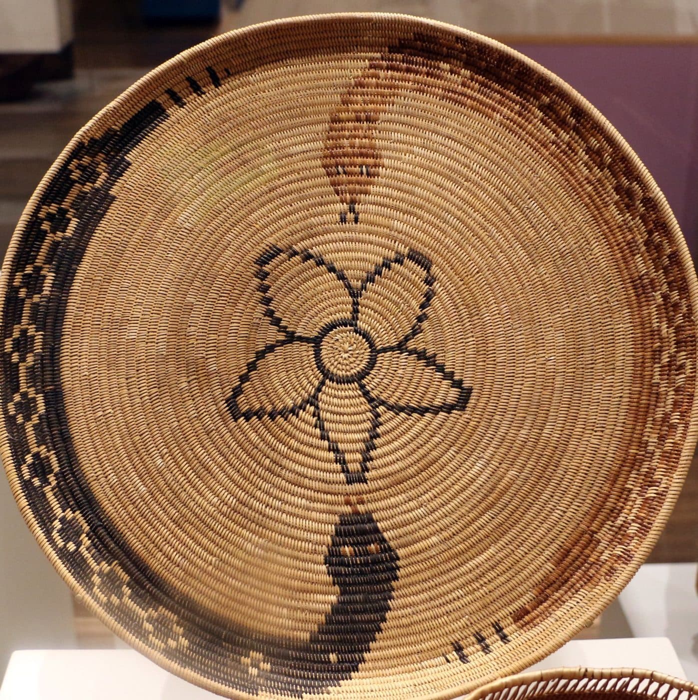 Coiled Kumeyaay basket by Eva Salazar: a four-lobed figure growing from the spiral at the center