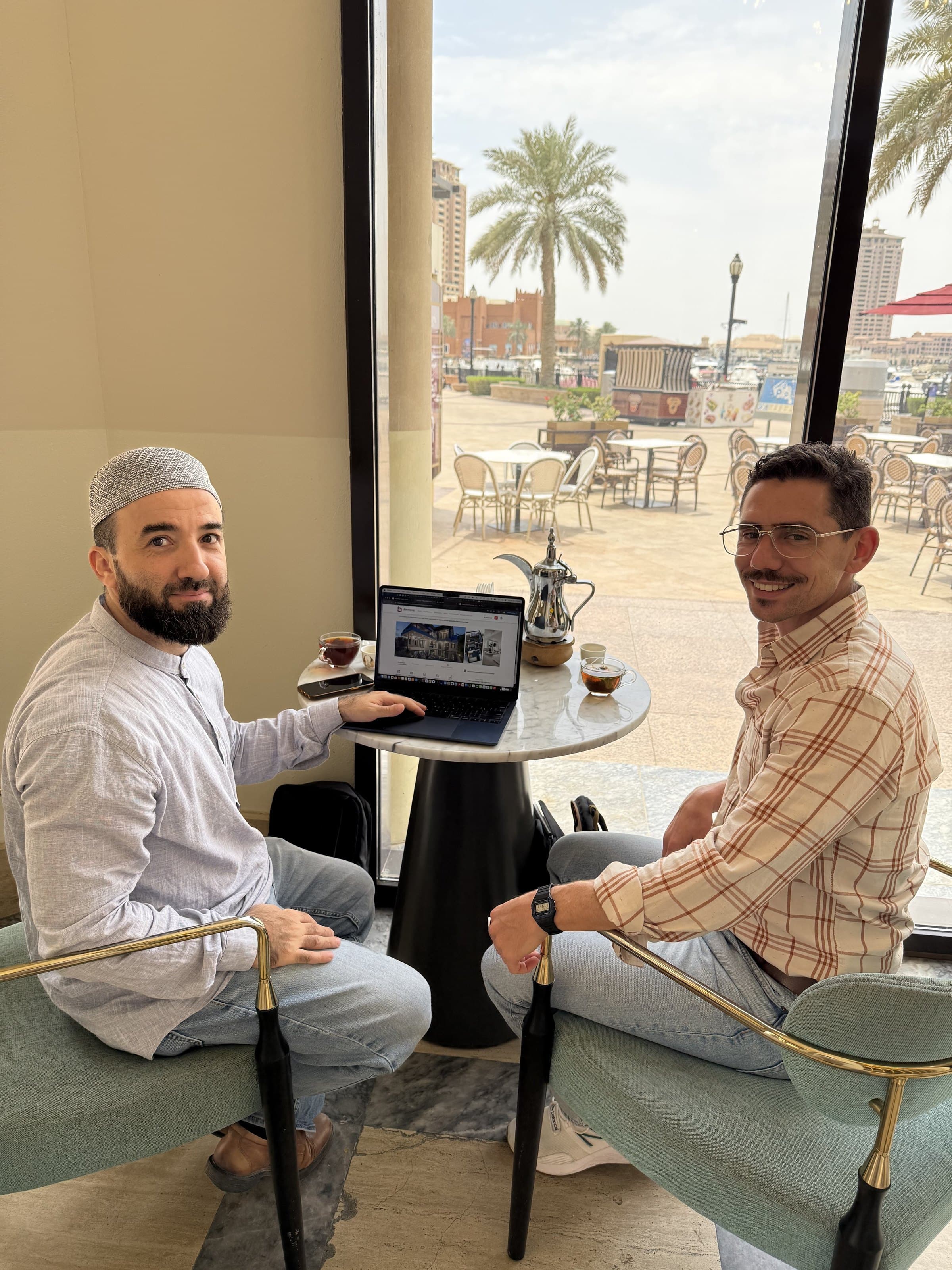 Joshua at a café table with a client, laptop between them