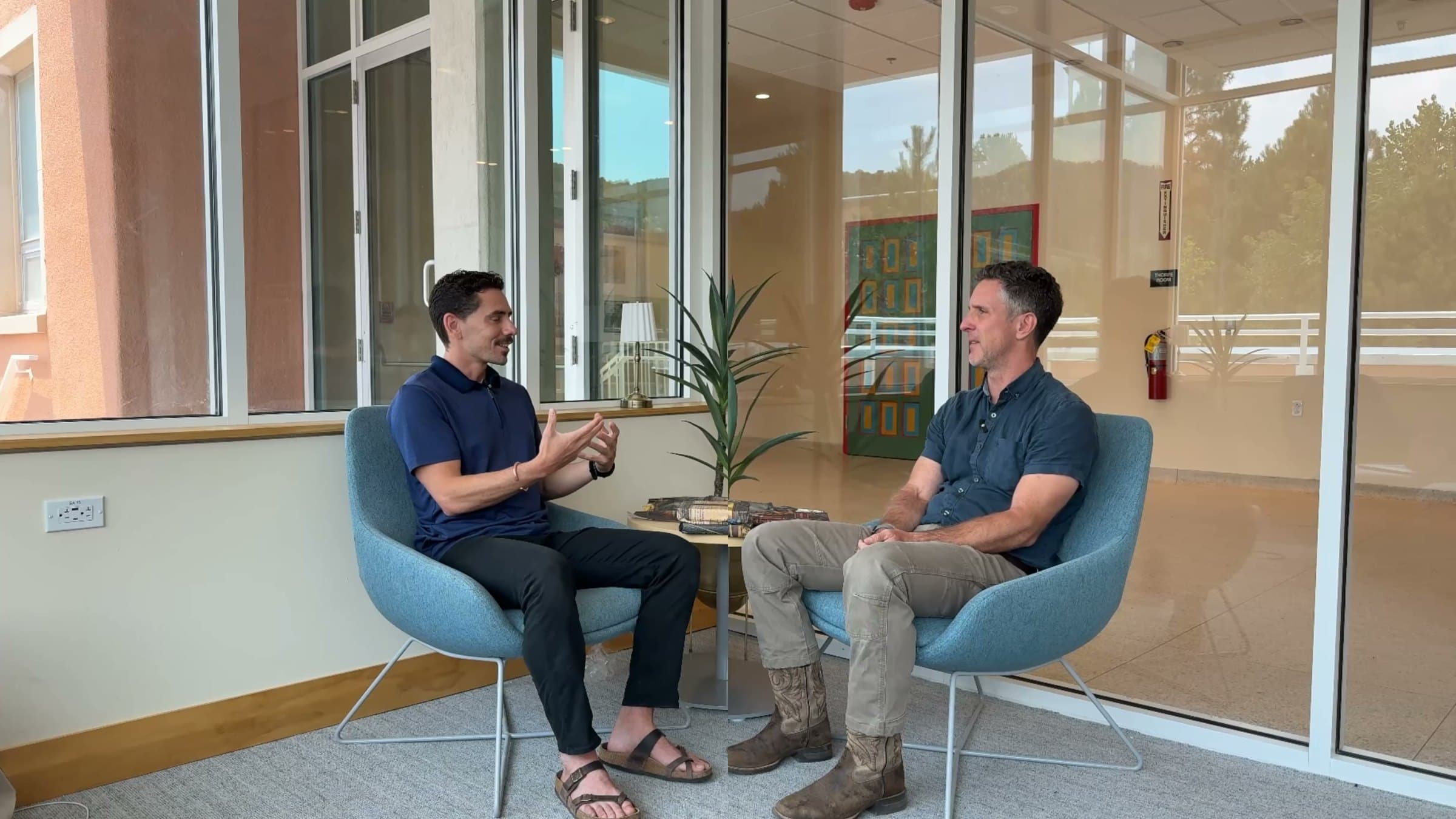 Joshua in conversation with a client, seated by a window